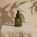 L'Arbre de paix Pureté Originelle fragrance-free signature oil in a green frosted glass bottle with a wooden dropper.