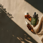 L'Arbre de paix Pureté Originelle fragrance-free signature oil bottles on a beige textured background with shadows.